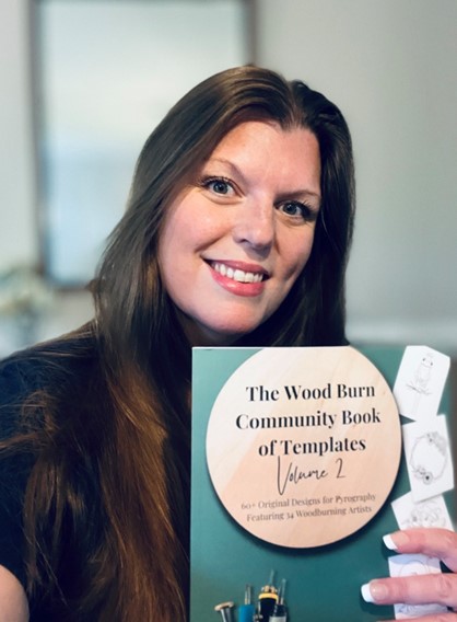 Author Andrea Pate holding a new book featuring her works